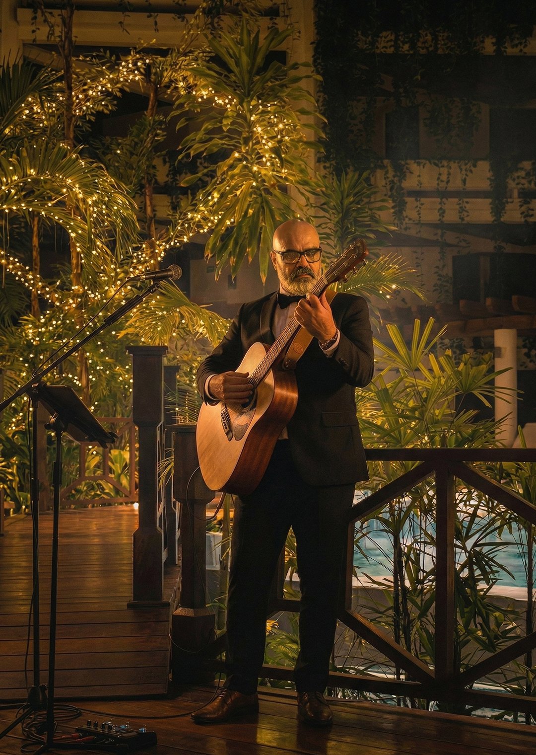 Rodo Acústico performing acoustic guitar at a destination wedding — elegant garden venue